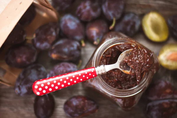 Üst manzara, cam kavanozdaki erik reçeli kaşıkla, ev yapımı tatlı.
