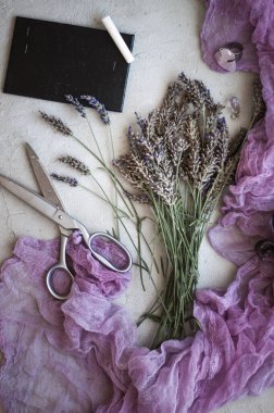 Menekşe lavanta çiçekleri, mor tekstil, makas ve tebeşir tahtası 