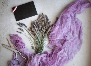 Menekşe lavanta çiçekleri, mor tekstil, makas ve tebeşir tahtası 