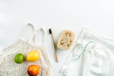 Sıfır atık ağ torbaları yeniden kullanılabilir paket, luffa ve beyaz arka planda bambu diş fırçası. Yüksek kalite fotoğraf