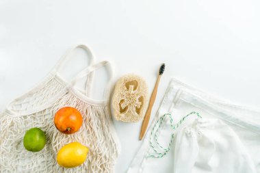 Sıfır atık ağ torbaları yeniden kullanılabilir paket, luffa ve beyaz arka planda bambu diş fırçası. Yüksek kalite fotoğraf