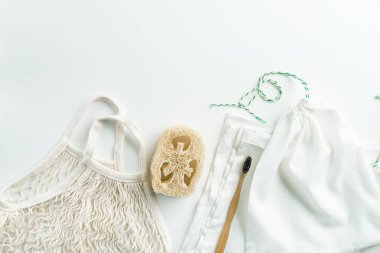 Sıfır atık ağ torbaları yeniden kullanılabilir paket, luffa ve beyaz arka planda bambu diş fırçası. Yüksek kalite fotoğraf