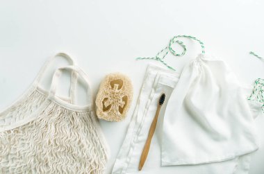 Sıfır atık ağ torbaları yeniden kullanılabilir paket, luffa ve beyaz arka planda bambu diş fırçası. Yüksek kalite fotoğraf
