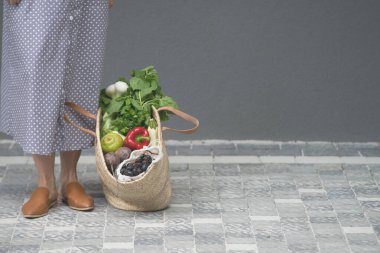 Naylon ambalajsız alışveriş yapmak için saman taşıyan bir kadın. minimalist kavram
