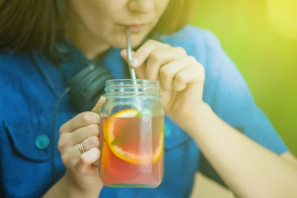 girl in cafe is drinking lemonade using metal reusable straw