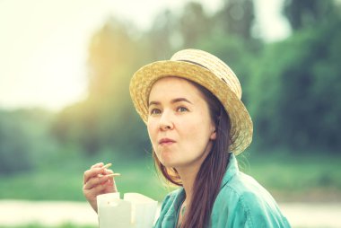 Genç beyaz kadın gün batımında Tayland yemeği yiyor. Yüksek kalite fotoğraf