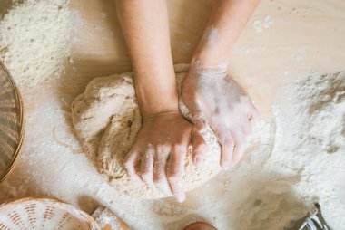Kadın hamuru kepekli un ve mayadan yoğuruyor.