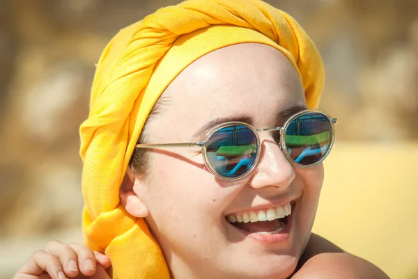 幸せな若い女性を笑顔で青いサングラスと黄色のスカーフ — ストック写真