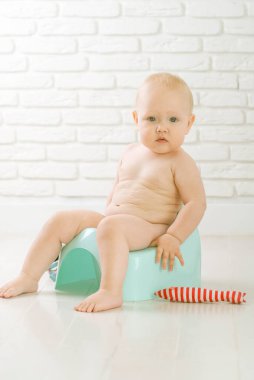 Cute baby training to piss into pot