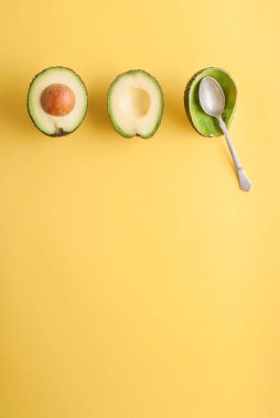 Sarı arka planda kaşık ile avakado çekimleri 