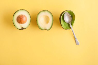 Sarı arka planda kaşık ile avakado çekimleri 