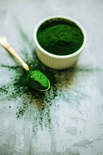 Beton zemin üzerinde beyaz plakalı spirulina tozu. Yüksek kalite fotoğraf