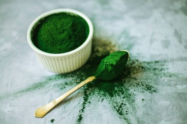 Beton zemin üzerinde beyaz plakalı spirulina tozu. Yüksek kalite fotoğraf