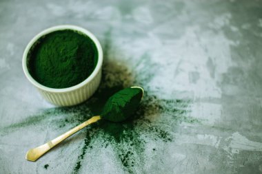 Beton zemin üzerinde beyaz plakalı spirulina tozu. Yüksek kalite fotoğraf