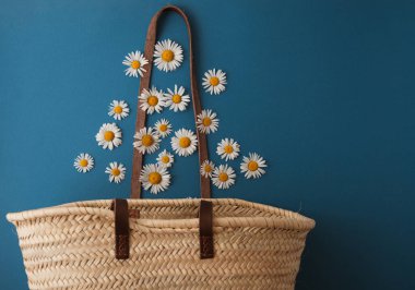daisies fall into a straw bag. summer concept