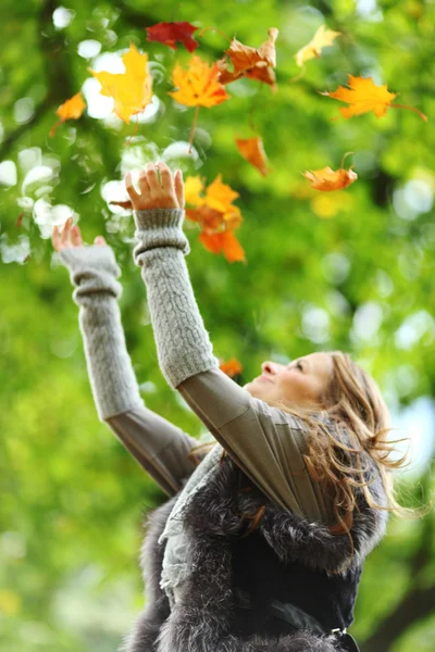 Femme goutte feuilles dans le parc d'automne — Photo