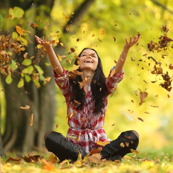 Vrouw drop bladeren in de herfst park Rechtenvrije Stockfoto's