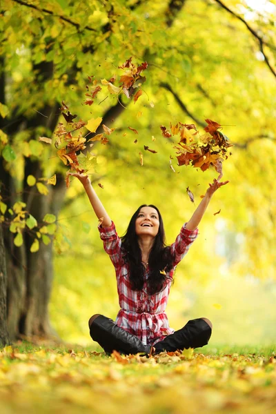 Donna foglie goccia nel parco autunnale — Foto Stock