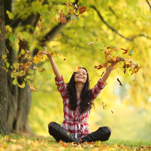 Donna foglie goccia nel parco autunnale — Foto Stock