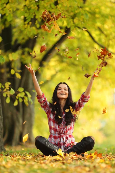 Donna foglie goccia nel parco autunnale — Foto Stock