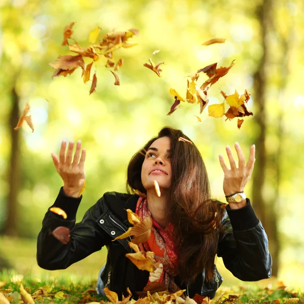 Femme goutte feuilles dans le parc d'automne — Photo