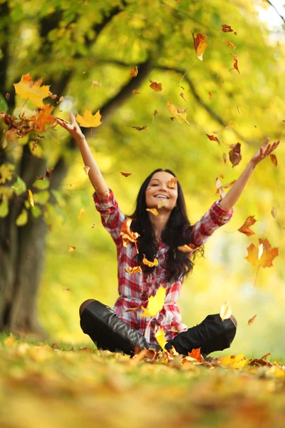 Vrouw drop bladeren in de herfst park Rechtenvrije Stockfoto's