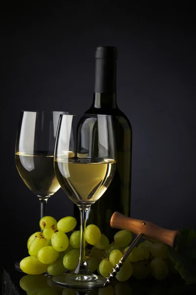 Garrafa com vinho branco e vidro e uvas — Fotografia de Stock