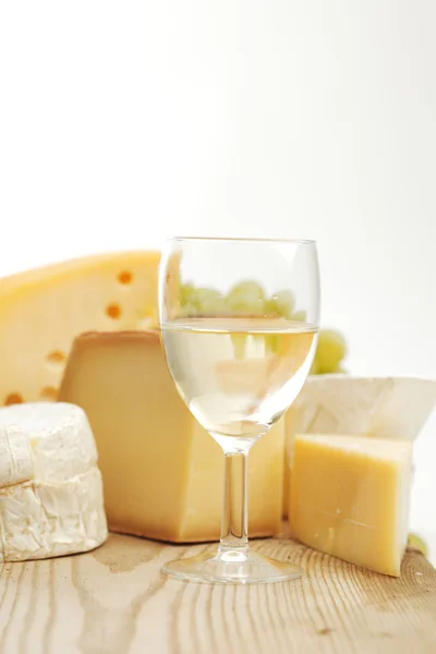 Queijo e vinho em uma mesa de madeira — Fotografia de Stock