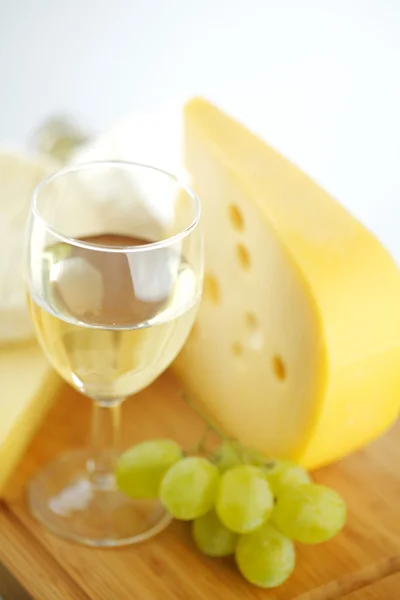 Queijo e vinho em uma mesa de madeira — Fotografia de Stock