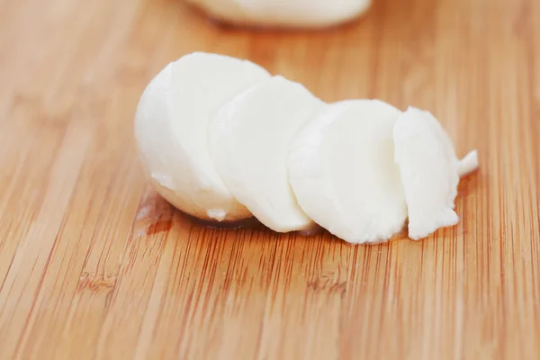 Sliced mozzarella on wooden board — Stock Photo, Image