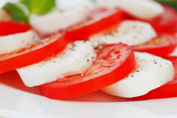 Rebanadas de tomate y mozzarella en un plato —  Fotos de Stock