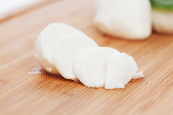 Sliced mozzarella on wooden board — Stock Photo, Image