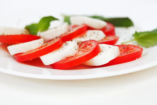 Rebanadas de tomate y mozzarella en un plato —  Fotos de Stock