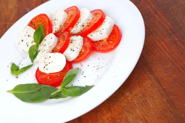 Mozzarella tomate queso y albahaca en un plato —  Fotos de Stock