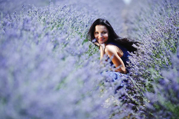 Mulher sentada em um campo de lavanda — Fotografia de Stock