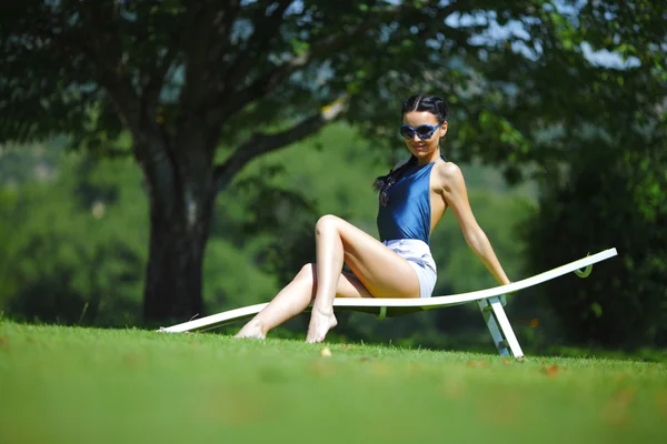 緑の芝生で白のラウンジで座っている女の子 — ストック写真