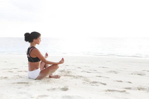 Žena jóga meditace u moře — Stock fotografie