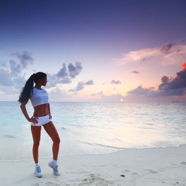Женщина в спортивной одежде на пляже — стоковое фото