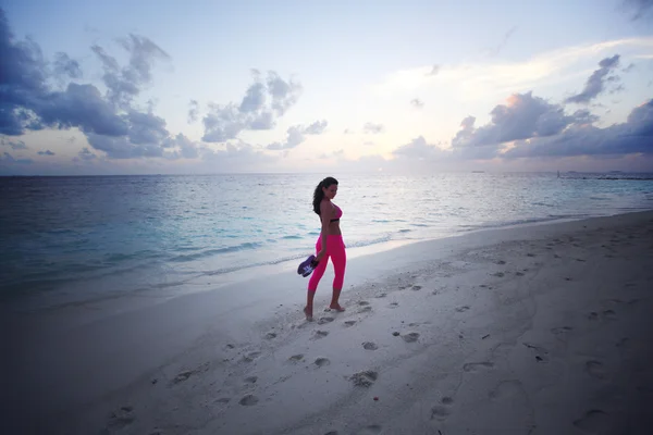 Femme pieds nus marchant le long de la plage — Photo