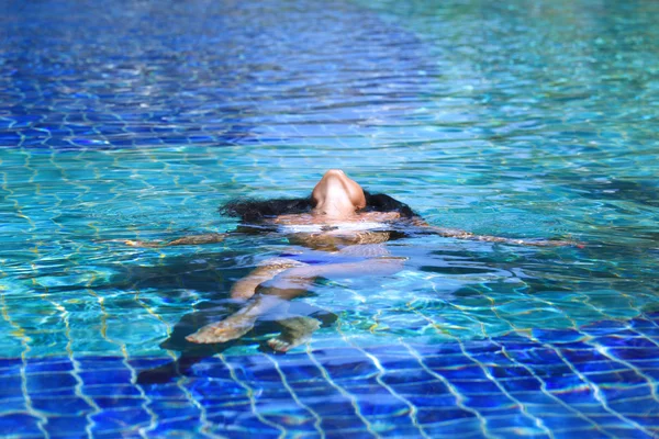 Mulher flutuando na piscina — Fotografia de Stock