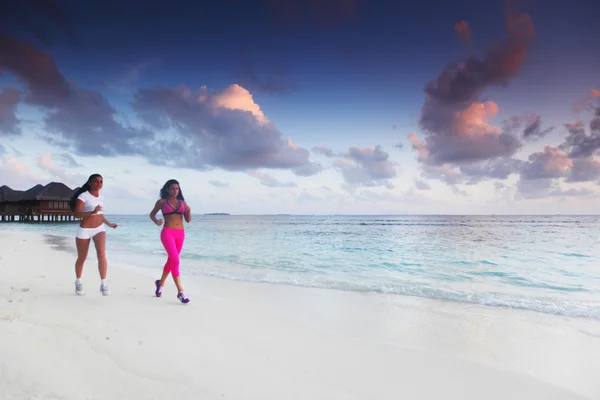 Duas mulheres correndo na praia — Fotografia de Stock