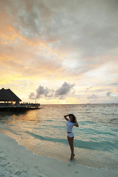 Femme sur la plage au coucher du soleil — Photo