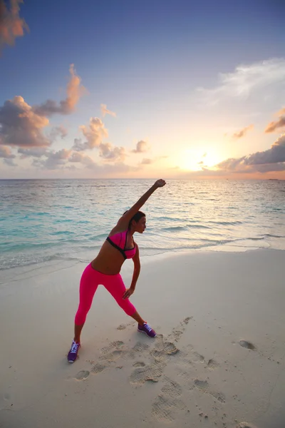 Woman stretching on beach — Stock Photo, Image