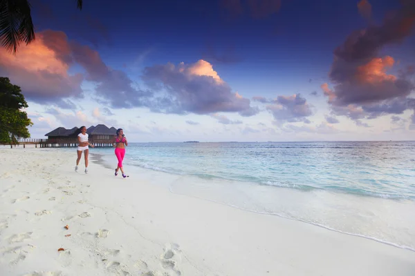 Twee vrouwen uitgevoerd op strand — Stockfoto