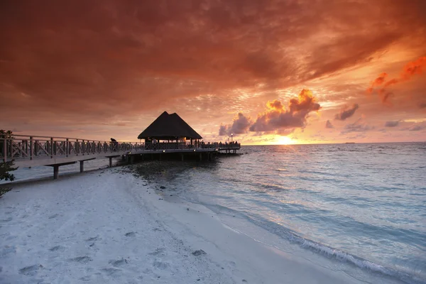 Praia e casas tropicais ao pôr do sol — Fotografia de Stock