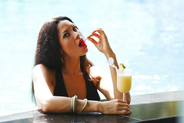 Mujer con cóctel en la piscina — Foto de Stock