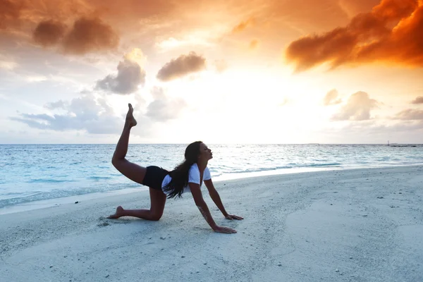 Donna di yoga sulla spiaggia al tramonto — Foto Stock