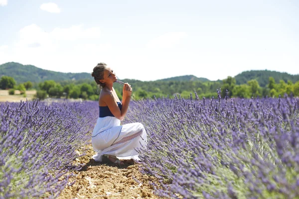 Woman sitting on a lavender field — Stock Photo, Image