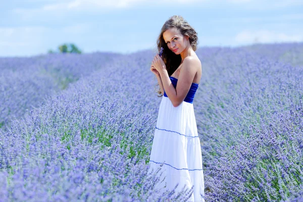 Kvinna stående på ett lavendelfält — Stockfoto