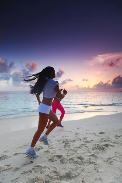 Dos mujeres corriendo en la playa — Foto de Stock
